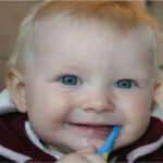 Baby boy with a toothbrush in his mouth dentist in euless