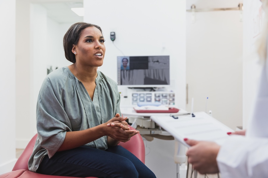 woman asking dentist if cavity under dental crown can be treated